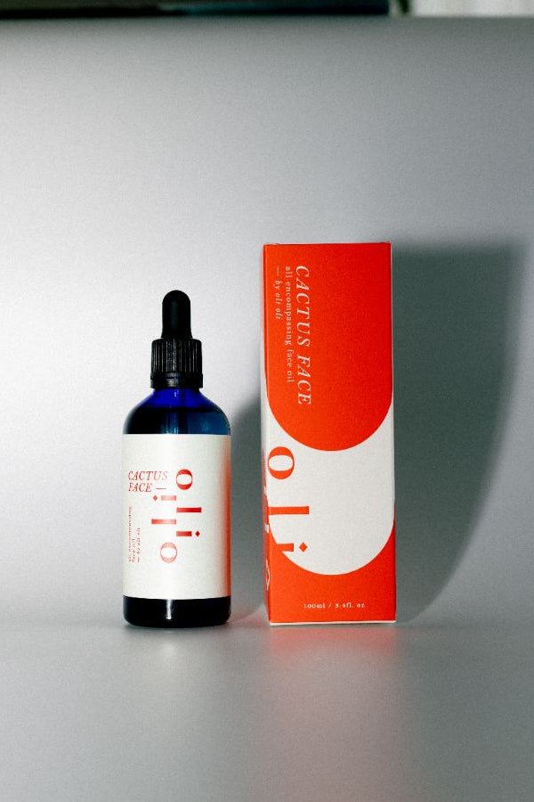 Bottle and box of cactus face, prickly pear seed face oil, skincare product on a gray surface